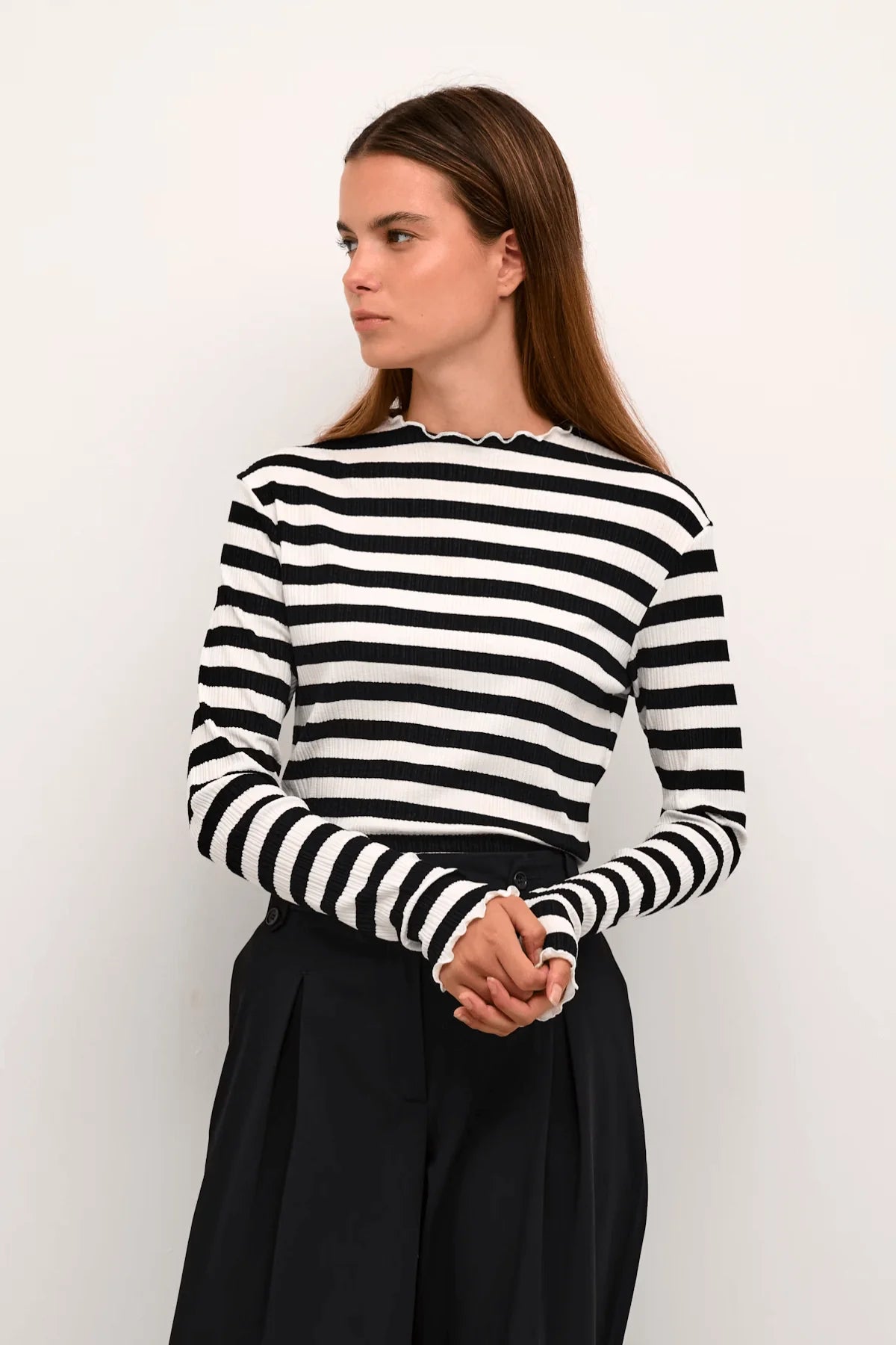 Woman wearing Candace black and white striped long sleeve top by Karen by Simonsen with black tailored trousers.